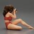 Woman photographer in bikini sitting and holding a camera image