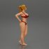 Fit hot woman in bikini taking off swimsuit panties on the beach image