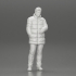 Man in long puffer jacket standing with his hand in his pocket lost in thought image